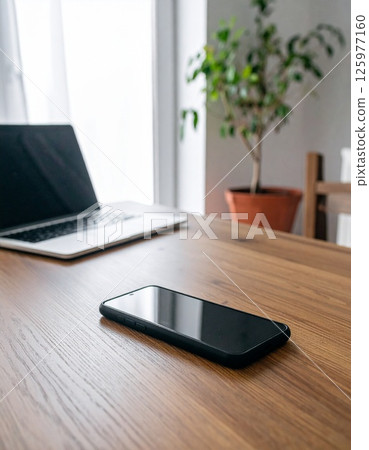 辦公桌上配備筆記型電腦和智慧型手機的遠端工作場景 125977160