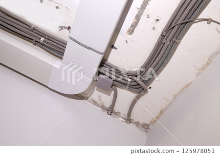 Installation of electrical wiring and ventilation on the ceiling. 125978051