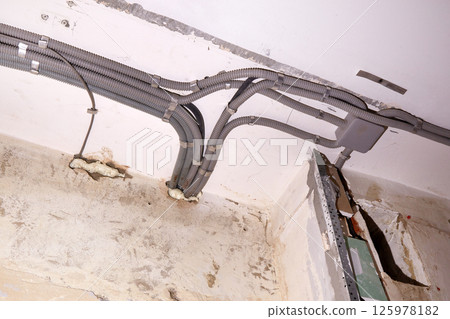 Installation of electrical wiring on the ceiling. 125978182