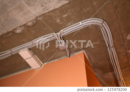 Installation of electrical wiring on the ceiling. Installation of electrical wiring on the ceiling. 125978200