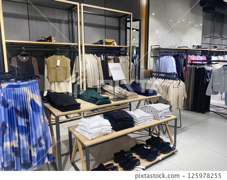 Contemporary retail store interior displaying casual women's summer wear 125978255
