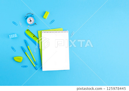 School supplies. Empty notebook, pens, ruler, alarm clock, paper clips 125978445