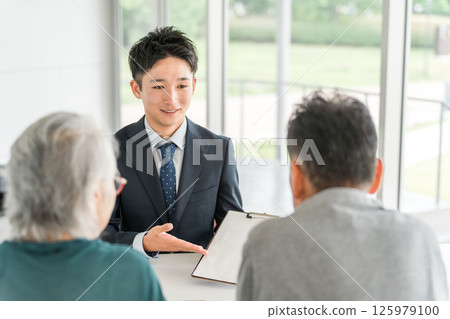 商人向老年夫婦解釋、提議、指導和推薦（銀行工作人員、資產管理、股票、投資、保險） 125979100