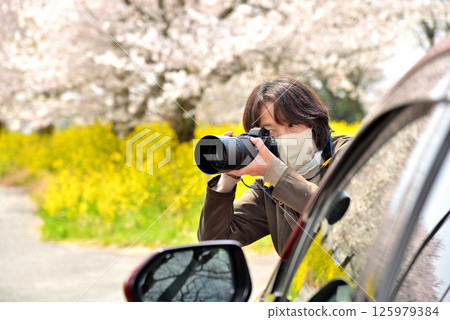 A woman taking a picture with a camera A woman taking a picture with a camera 125979384