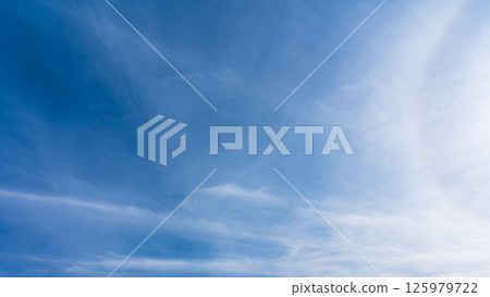 The "Halo Phenomenon" is a mysterious halo of thin clouds and the sun in a clear blue sky. 125979722