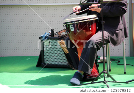 Djembe player performing outdoors 125979812