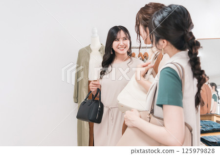 年輕的亞洲女性顧客與朋友一起購物 年輕的亞洲女性顧客與朋友一起購物 125979828