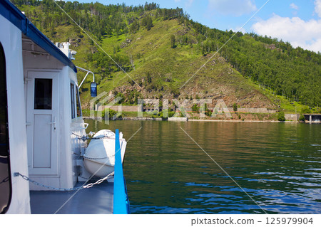 Summer cruise. View from the deck of the ship on the shore of Lake Baikal, mountains, forest. Summer cruise. View from the deck of the ship on the shore of Lake Baikal, mountains, forest. 125979904