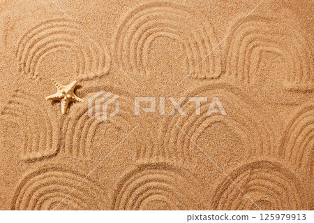 A pattern in the form of waves on the sand on the beach and a starfish. A pattern in the form of waves on the sand on the beach and a starfish. 125979913