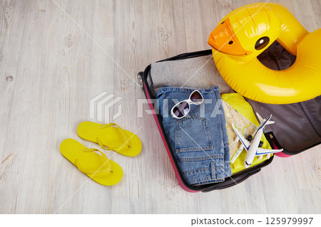 Suitcase with clothes and leisure accessories. Summer travel. Suitcase with clothes and leisure accessories. Summer travel. 125979997