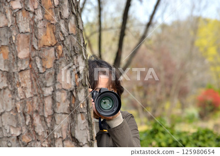 A woman taking a picture with a camera 125980654