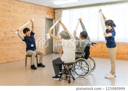 在養老院和日託中心鍛鍊和伸展身體的老年男女以及工作人員 在養老院和日託中心鍛鍊和伸展身體的老年男女以及工作人員 125980999