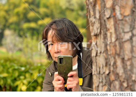 Woman taking a photo with a mobile phone camera 125981151