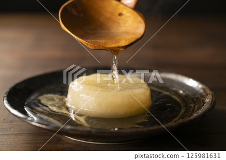 Pour soup stock over simmered daikon radish 125981631