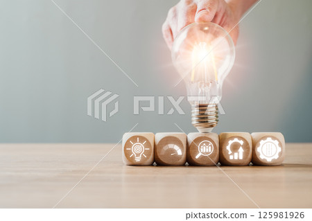 Light bulb and wooden blocks illustrating the DMAIC process: Define, Measure, Analyze, Improve, Control in business strategy. Light bulb and wooden blocks illustrating the DMAIC process: Define, Measure, Analyze, Improve, Control in business strategy. 125981926