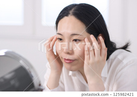 關注細紋和皺紋的中年女性 關注細紋和皺紋的中年女性 125982421