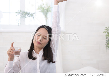 在客廳裡的中年女人喝水 在客廳裡的中年女人喝水 125982962