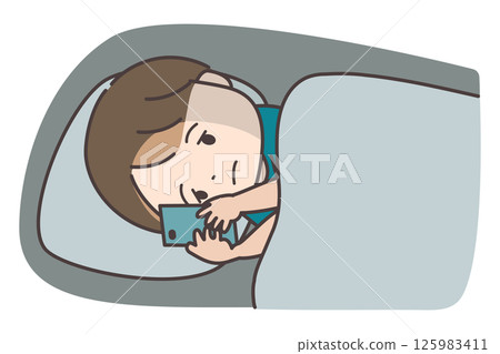 一個男孩晚上躺在床上看智慧型手機 一個男孩晚上躺在床上看智慧型手機 125983411