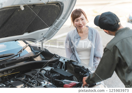 男機械人員在汽車引擎室向司機解釋 125983973