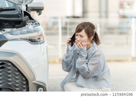 一名女駕駛在發生車禍後用智慧型手機撥打電話(道路服務) 一名女駕駛在發生車禍後用智慧型手機撥打電話(道路服務) 125984106