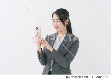 A woman with a suit with a smartphone 125984334