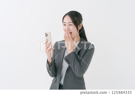 A woman with a suit with a smartphone 125984335