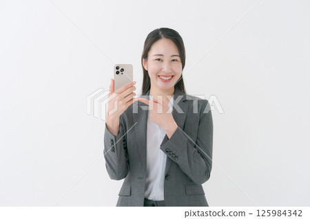 A woman with a suit with a smartphone A woman with a suit with a smartphone 125984342