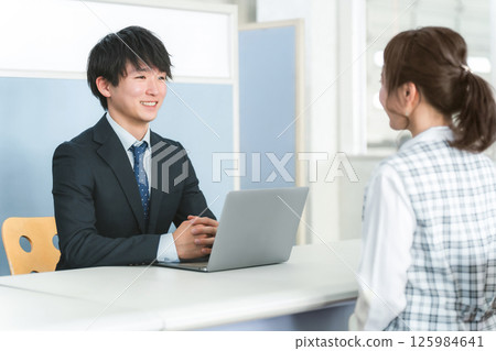 Young Asian businessman serving female customers at reception desk 125984641