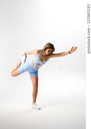 Fitness enthusiast engaged in an intense workout routine in minimalistic studio setting 125985283