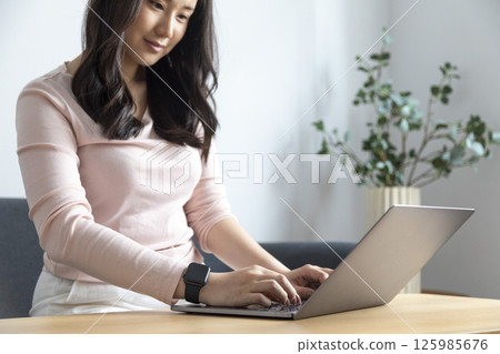 Work from home, Happy Asian young businesswoman use hand finger touch screen modern laptop computer she wears a smart watch on the wrist focus on smartwatch Work from home, Happy Asian young businesswoman use hand finger touch screen modern laptop computer she wears a smart watch on the wrist focus on smartwatch 125985676