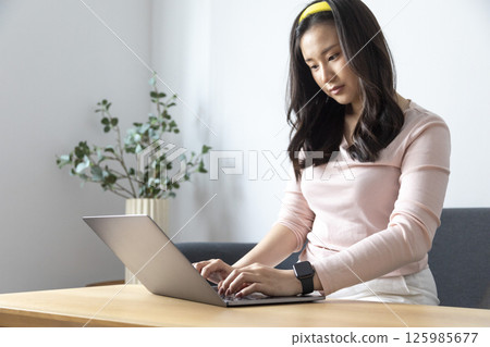 Work from home, Happy Asian young businesswoman use hand finger touch screen modern laptop computer she wears a smart watch on the wrist focus on smartwatch Work from home, Happy Asian young businesswoman use hand finger touch screen modern laptop computer she wears a smart watch on the wrist focus on smartwatch 125985677