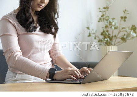 Work from home, Happy Asian young businesswoman use hand finger touch screen modern laptop computer she wears a smart watch on the wrist focus on smartwatch Work from home, Happy Asian young businesswoman use hand finger touch screen modern laptop computer she wears a smart watch on the wrist focus on smartwatch 125985678