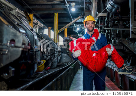 First aid support accident at work of worker at factory. Male worker has an accident on the floor in warehouse site. First aid support accident at work of worker at factory. Male worker has an accident on the floor in warehouse site. 125986871