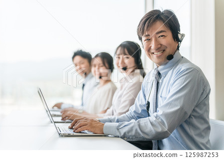 呼叫中心操作員團隊的男性和女性(遠端操作/遠端預約) 呼叫中心操作員團隊的男性和女性(遠端操作/遠端預約) 125987253