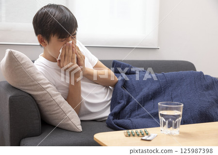 boy blow his nose. Sick child with napkin in bed. Allergic kid, flu season. Kid with cold rhinitis, get cold snot nose boy blow his nose. Sick child with napkin in bed. Allergic kid, flu season. Kid with cold rhinitis, get cold snot nose 125987398