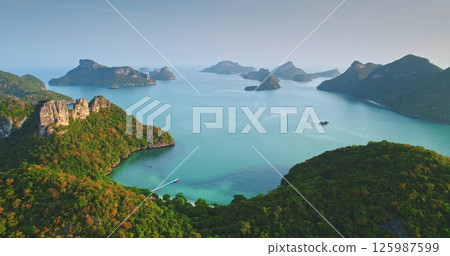Aerial view capturing the stunning Mu Ko Ang Thong National Park, featuring 42 islands with towering limestone cliffs, lush vegetation, hidden lagoons, and turquoise waters 125987599