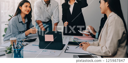 Team of financial advisory services. Asian advisor showing plan of investment to clients in the consultancy office. 125987847