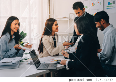 Team of financial advisory services. Asian advisor showing plan of investment to clients in the consultancy office. 125987852