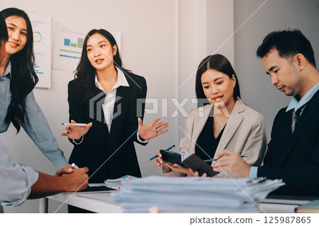 Team of financial advisory services. Asian advisor showing plan of investment to clients in the consultancy office. 125987865