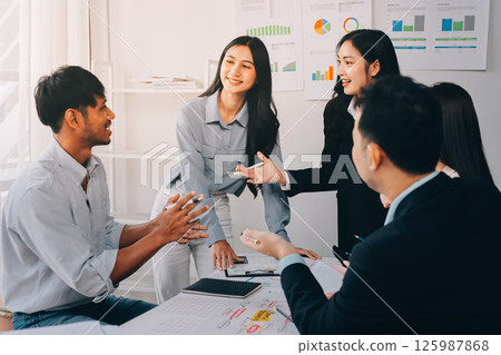 Team of financial advisory services. Asian advisor showing plan of investment to clients in the consultancy office. 125987868