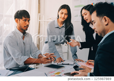 Team of financial advisory services. Asian advisor showing plan of investment to clients in the consultancy office. 125987869