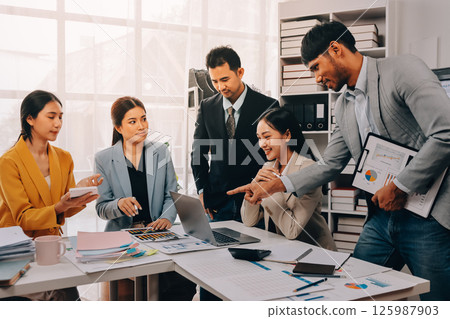 Team of financial advisory services. Asian advisor showing plan of investment to clients in the consultancy office. Team of financial advisory services. Asian advisor showing plan of investment to clients in the consultancy office. 125987903