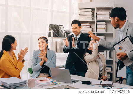 Group of Young Asian business team creative businesspeople coworker in office Happy to be successful partnership teamwork celebrating achievement and success concept. Group of Young Asian business team creative businesspeople coworker in office Happy to be successful partnership teamwork celebrating achievement and success concept. 125987906