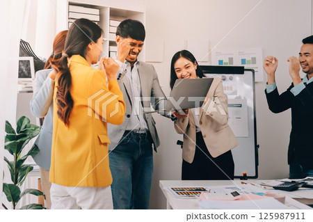 Group of Young Asian business team creative businesspeople coworker in office Happy to be successful partnership teamwork celebrating achievement and success concept. Group of Young Asian business team creative businesspeople coworker in office Happy to be successful partnership teamwork celebrating achievement and success concept. 125987911