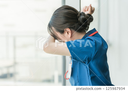 A woman who is a doctor, doctor, nurse, medical worker, or engineer who feels regret after banging on the hospital window 125987934