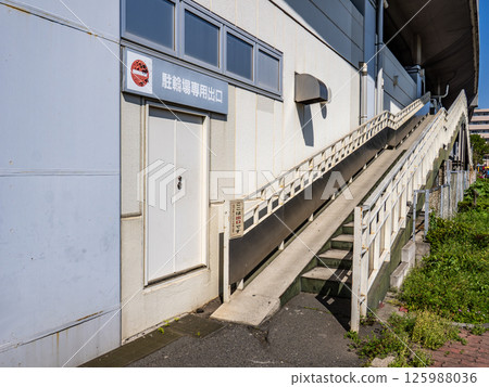 The exit to the paid bicycle parking lot in front of the station under the railway overpass The exit to the paid bicycle parking lot in front of the station under the railway overpass 125988036