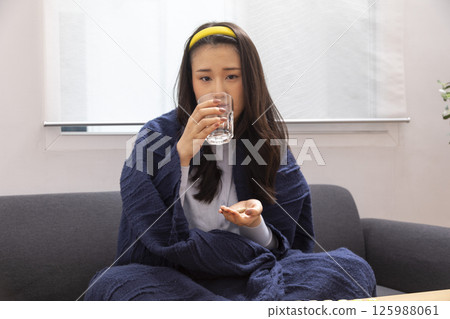 Sick woman lying in bed with high fever. Cold, flu, fever and migraine Sick woman lying in bed with high fever. Cold, flu, fever and migraine 125988061