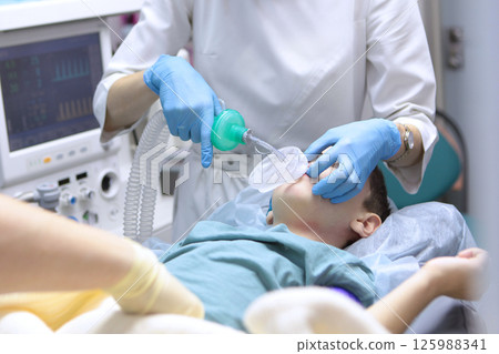 Child is under anesthesia. Treatment of baby teeth under general anesthesia. Breathing tube is inserted into child's throat. Concept of healthcare. Child is under anesthesia. Treatment of baby teeth under general anesthesia. Breathing tube is inserted into child's throat. Concept of healthcare. 125988341