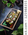 Rolls in tempura with smoked salmon and green onions. Traditional Japanese cuisine. Vertical photo. 125988355