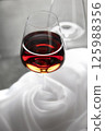 Red wine glass on white cloth background. Neutral background. 125988356